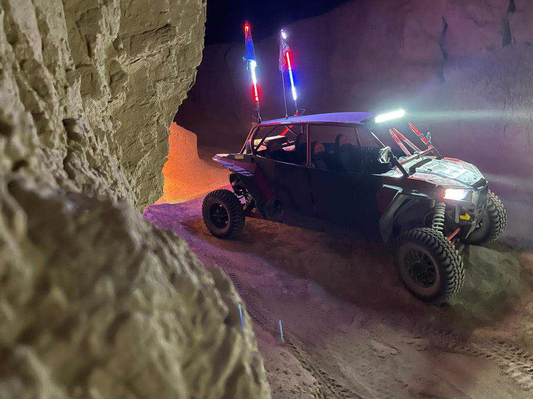 UTV with LED whips and D2D flag glowing through dune wall corridor at night | Dunes 2 Dezert