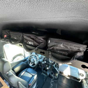 Rugged Radios large storage bags lined up on a Sprinter van overhead shelf for organized gear storage