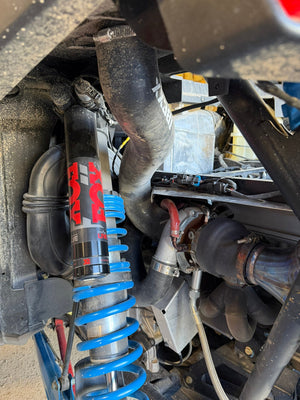 Close view of the Ibexx Pro R intake tube routing under the cage alongside the upgraded intercooler