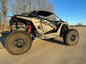 L&W Fab Polaris RZR Turbo R / Pro S rock sliders and tree kickers on a 2-seat off-road vehicle for added protection.