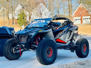 L&W Fab Polaris RZR Turbo R / Pro S two-seat rock sliders and tree kickers mounted on side of off-road vehicle.