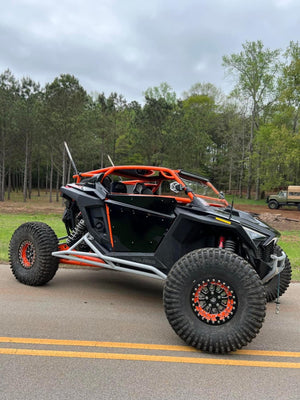 L&W Fab Polaris RZR Pro R 2-seat rock sliders and tree kickers installed on side of off-road vehicle for protection.