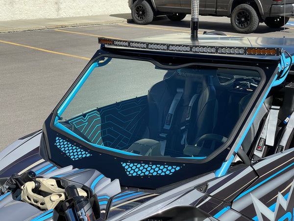 Moto Armor full glass windshield for Can-Am Maverick X3 with Voodoo Riders cage, featuring vents, DOT glass, and billet mounts.